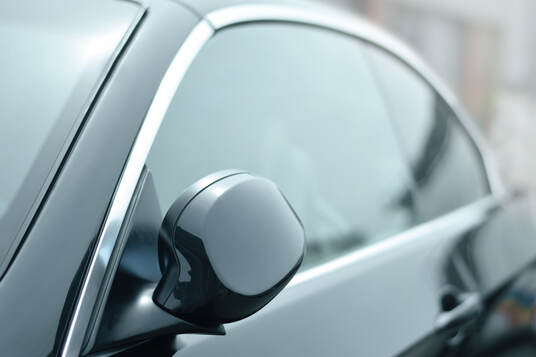 Close up picture of black sedan in Puyallup, Washington with tinted windows.